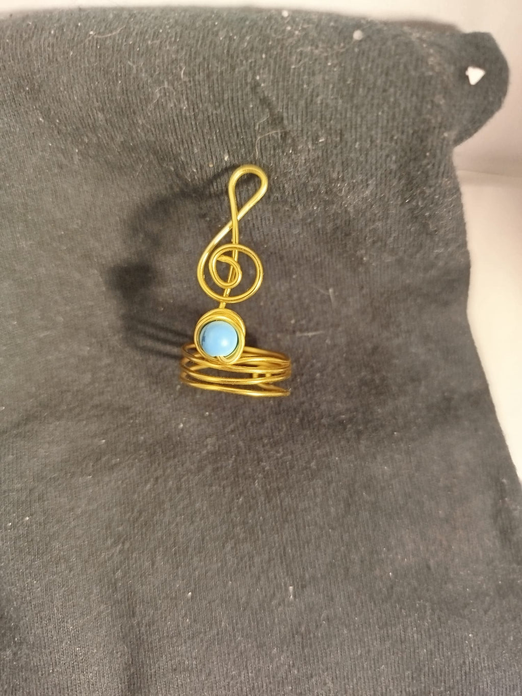Anillo de alambre dorado con clave de sol con turquesa