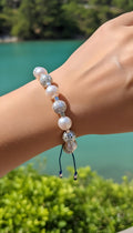 Pulsera de hilo azul con abalorios plateados y perlas