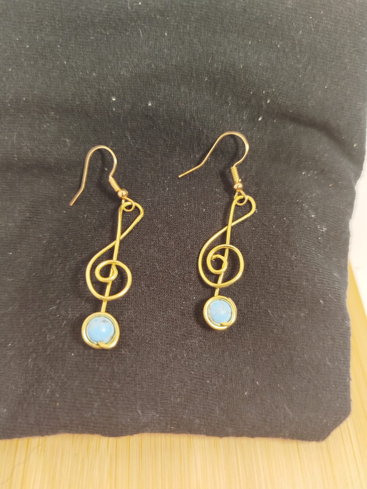 Clave de sol dorada con turquesa