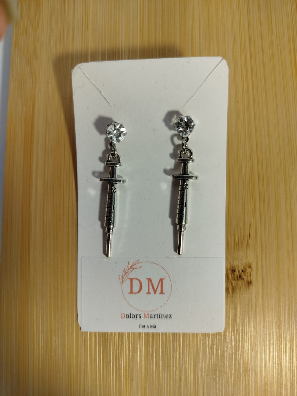 Pendientes plateados con forma de jeringuilla y cierre a presión